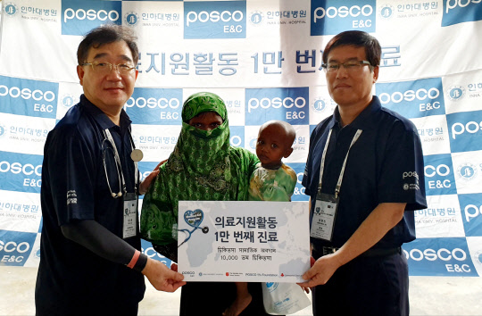 포스코건설 의료봉사단이 해외 의료 봉사활동 1만명째 의료지원을 달성하고 기념촬영을 하고 있다. <포스코건설 제공>